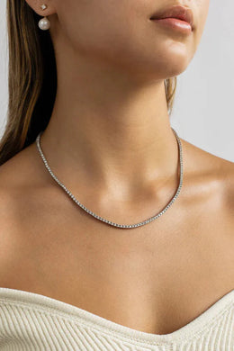 A woman with her hair back wearing the Sewar Celestial River Tennis Necklace, a delicate sterling silver necklace set with a continuous line of small, sparkling white stones.