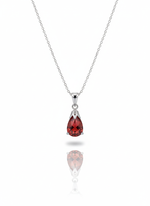 A sterling silver necklace with a key-shaped pendant on a soft neutral background. The head of the key features a cutout four-leaf clover design, and the piece has a high-polish finish.